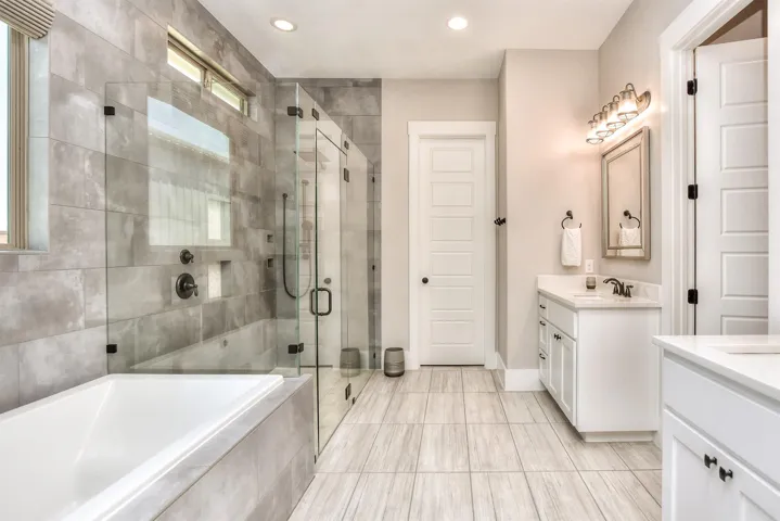Bathroom featuring two vanities, a shower stall, a garden tub, recessed lighting, and tile patterned floors