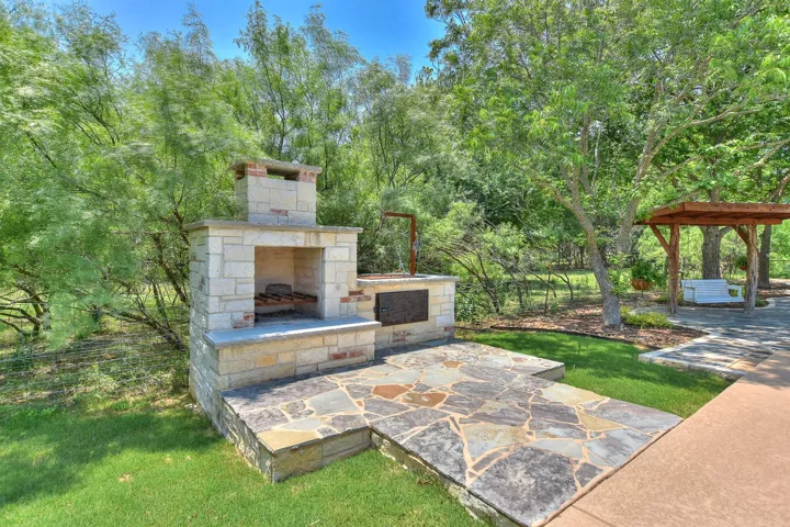 View of patio with an outdoor stone fireplace
