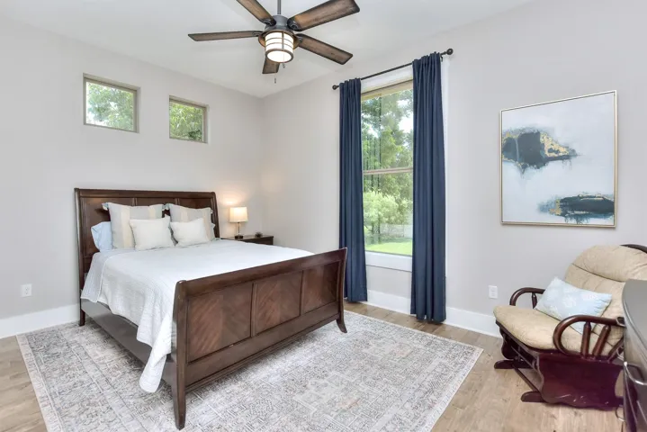 Bedroom featuring wood finished floors, baseboards, and a ceiling fan