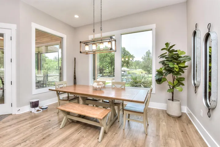 Dining space with light wood finished floors, baseboards, recessed lighting, and a chandelier
