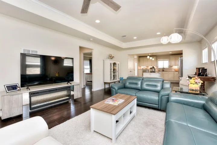 Living room featuring ornamental molding, recessed lighting, wood finished floors, a ceiling fan, and baseboards