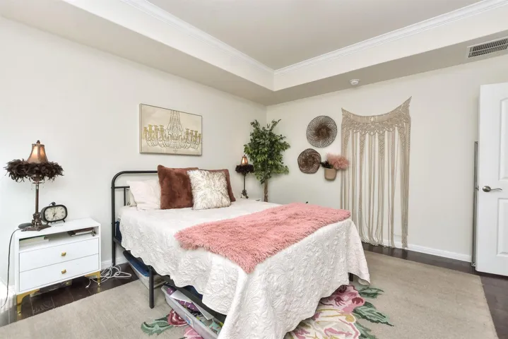 Bedroom featuring crown molding, wood finished floors, and baseboards