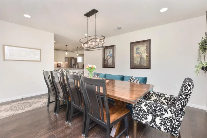 Dining space with dark wood-style flooring, recessed lighting, a chandelier, and baseboards