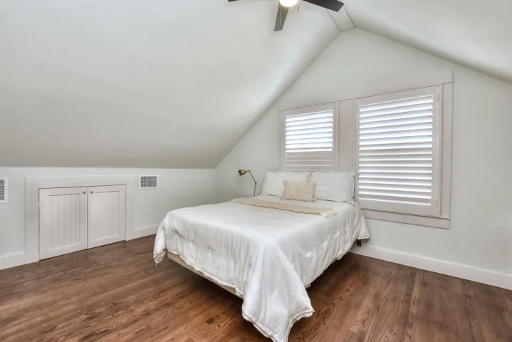 Bedroom featuring lofted ceiling, wood finished floors, and ceiling fan