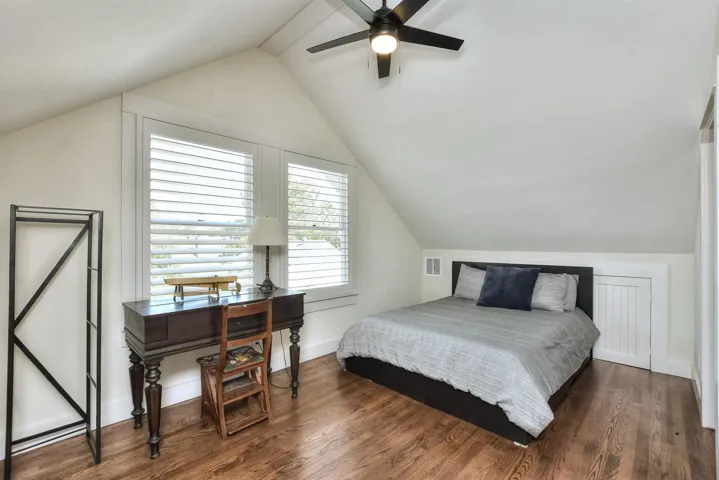 Bedroom with vaulted ceiling, wood finished floors, and ceiling fan