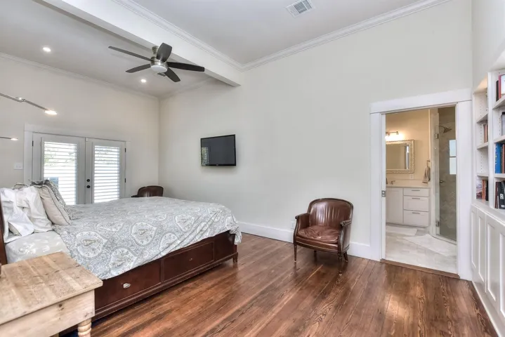 Bedroom with hardwood / wood-style floors, ornamental molding, french doors, ceiling fan, and ensuite bath