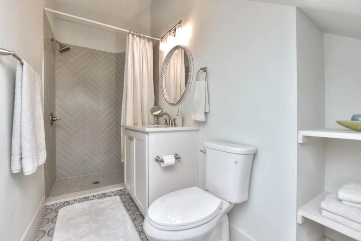 Bathroom with vanity, tiled shower, and tile patterned floors