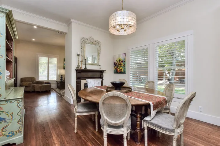 Dining area featuring dark wood-style floors, crown molding, and a chandelier