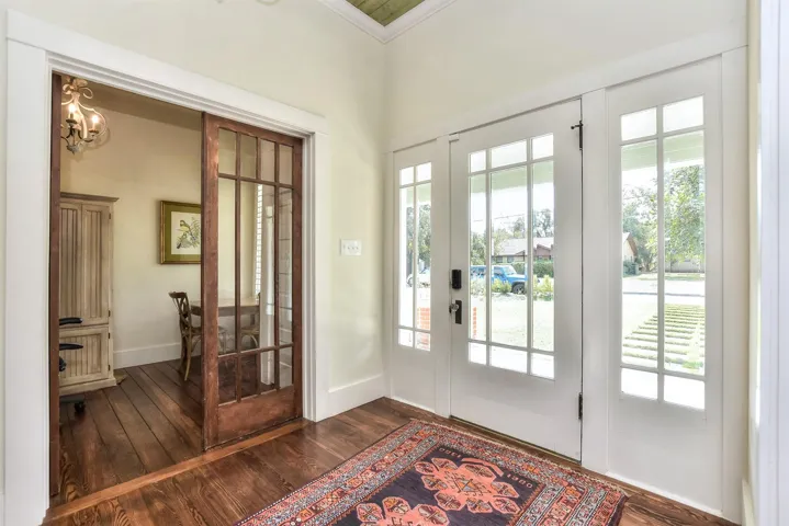 Entrance foyer featuring ornamental molding, healthy amount of natural light, dark wood-style flooring, and a chandelier