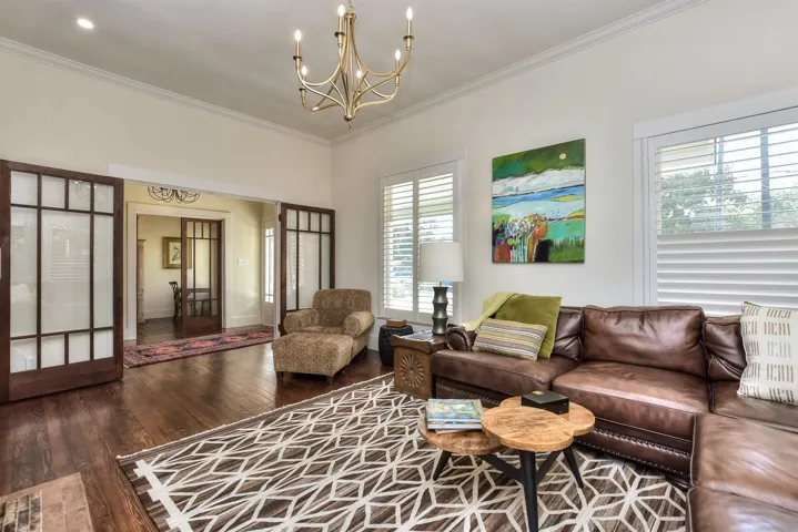 Living room featuring a chandelier, ornamental molding, and wood finished floors