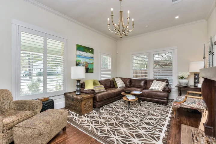 Living room featuring a chandelier, wood finished floors, and crown molding