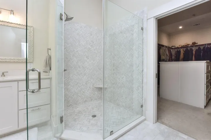 Full bath with a stall shower, a walk in closet, and vanity