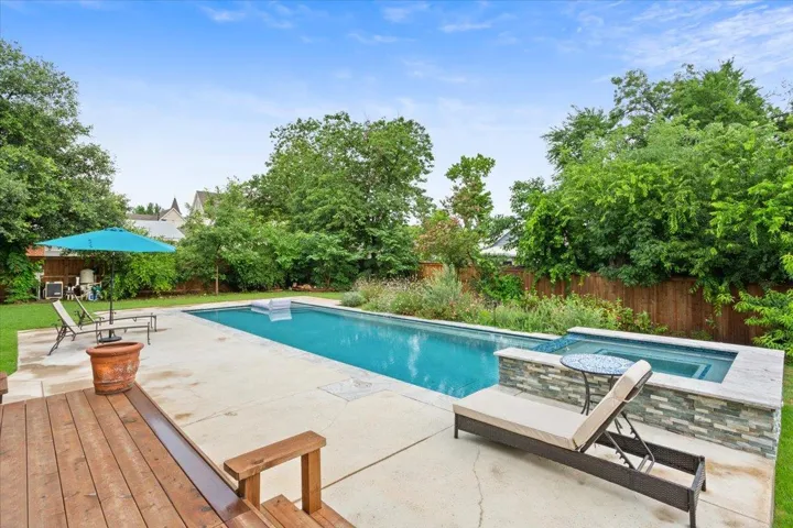 View of swimming pool with an in-ground hot tub, a fenced backyard, and a patio