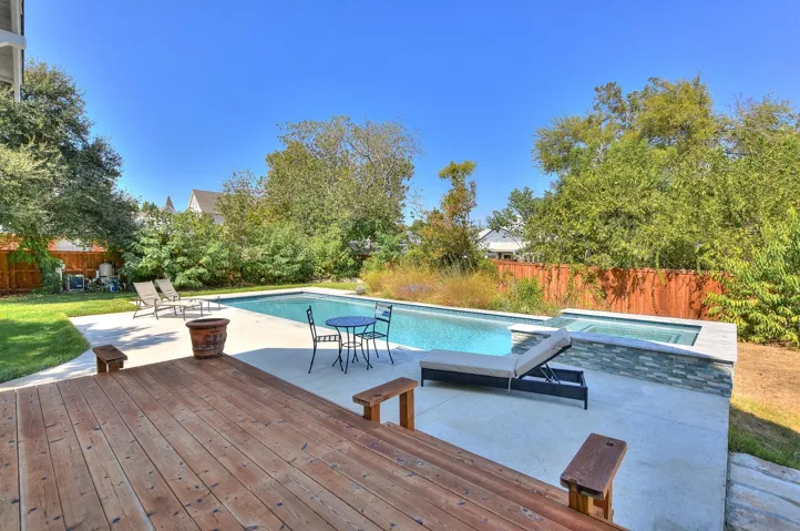 View of swimming pool featuring an in-ground hot tub, a patio, a fenced backyard, and a deck