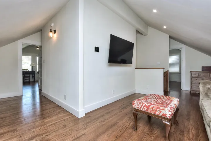Living area featuring vaulted ceiling, wood finished floors, recessed lighting, and ceiling fan