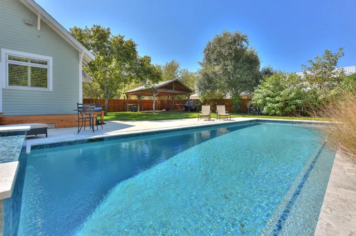 View of swimming pool featuring a gazebo, a fenced backyard, and a patio area