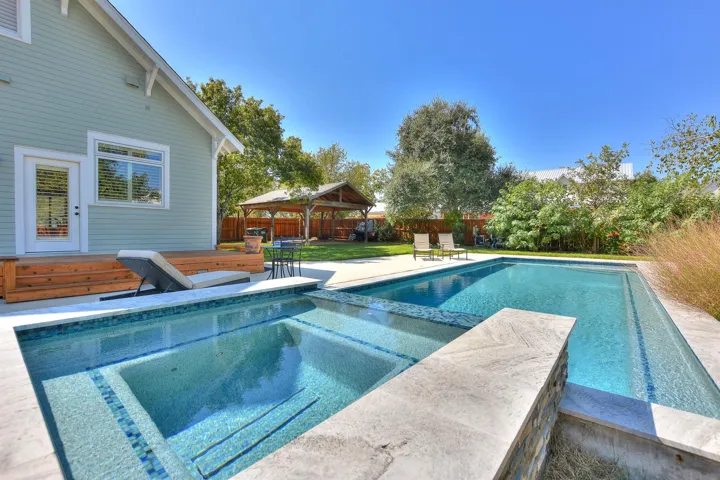View of pool with a gazebo, a fenced backyard, a patio area, and a pool with connected hot tub