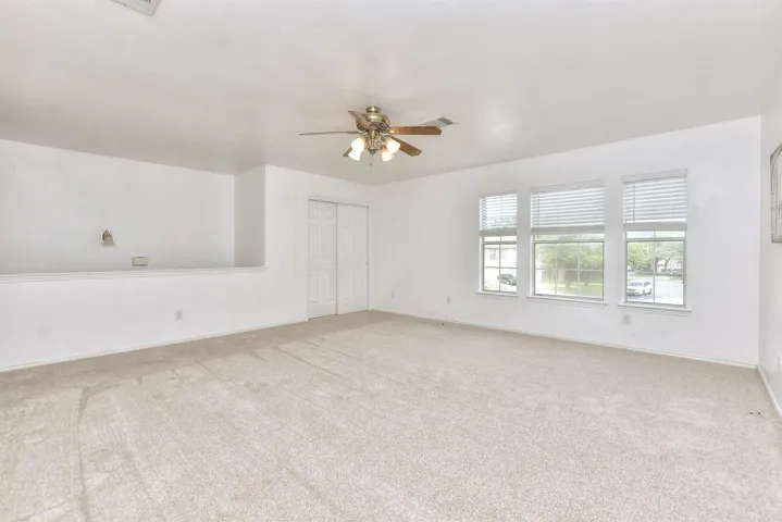 Another view of the upstairs bonus/game/flex space showing 1 set of closet doors.
