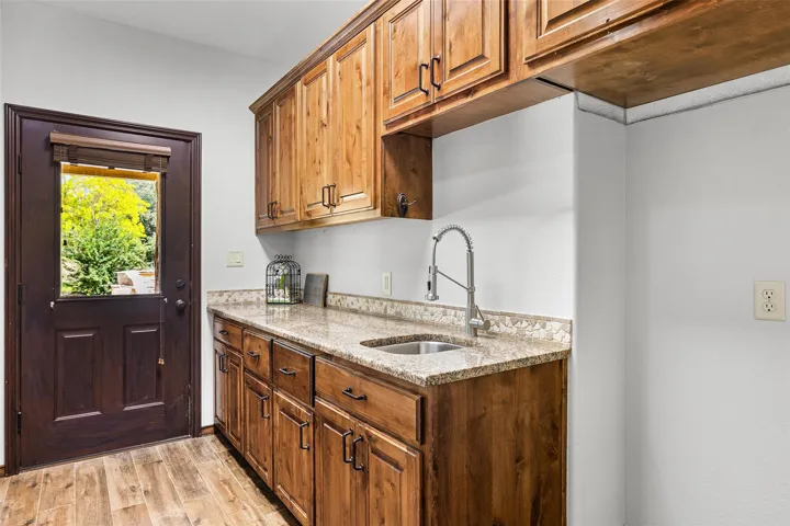 Oversized laundry room with ample cabinet space, sink and plenty of cabinet storage