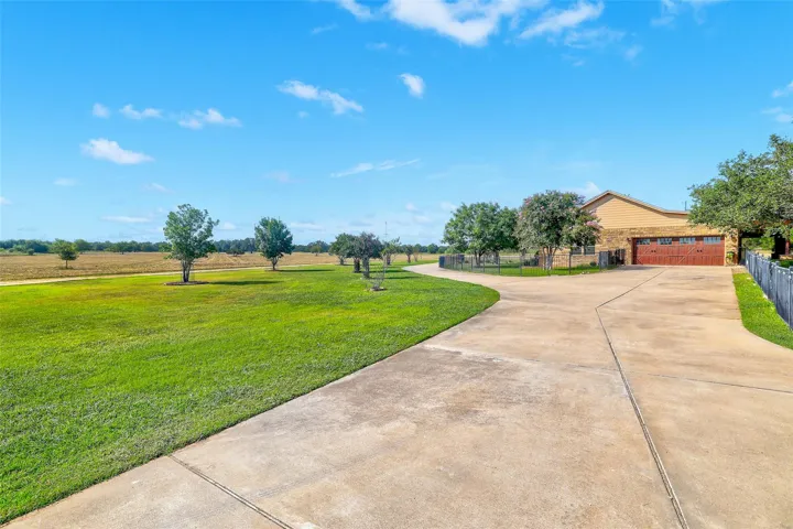 Expansive concrete driveway provides plenty of room for trailers, RVs, and additional parking needs
