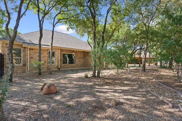 Rear view of property featuring a patio area and a shingled roof
