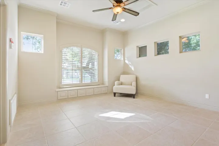 Living area featuring ceiling fan, crown molding, and light tile patterned floors