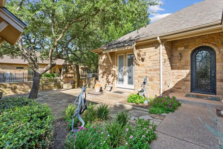 Doorway to property featuring stone siding and a shingled roof
