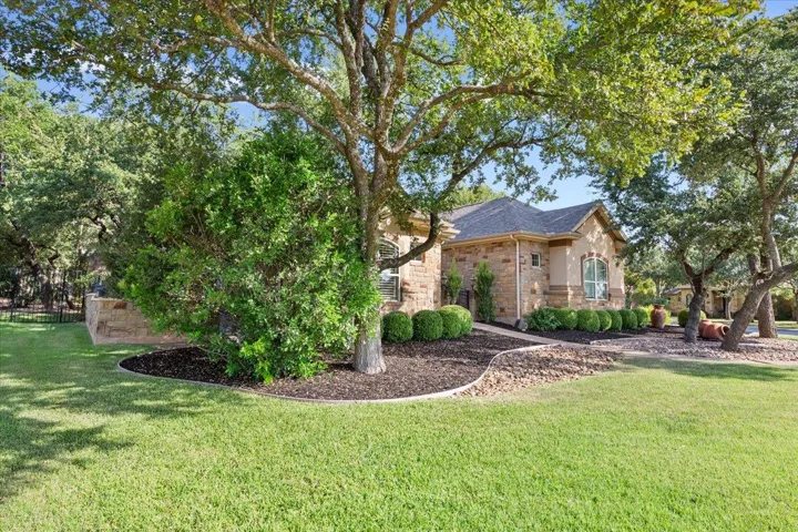 View of front of property featuring stone siding and a front lawn