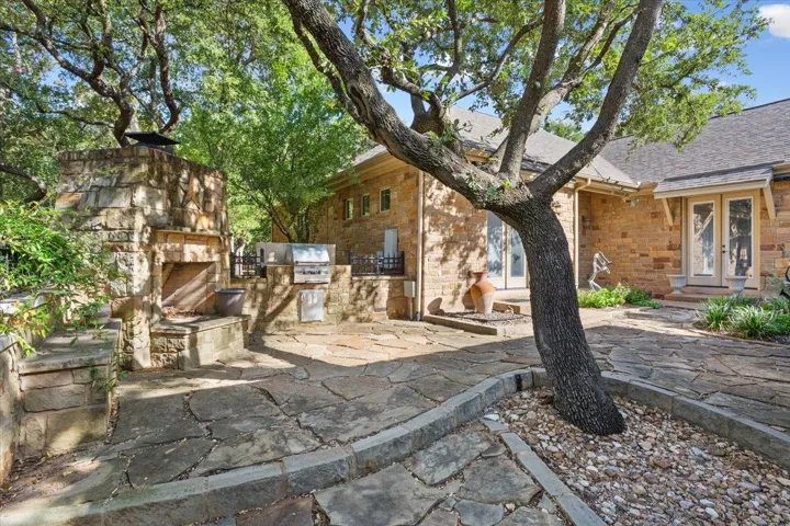 View of patio / terrace with area for grilling and an outdoor stone fireplace