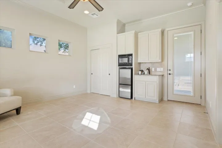 Kitchen featuring plenty of natural light, ornamental molding, light tile patterned floors, backsplash, and recessed lighting