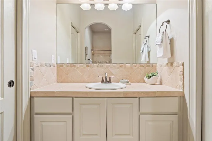 Bathroom featuring decorative backsplash and vanity