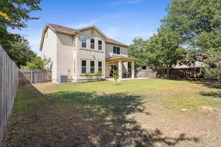Back of house with stucco siding, a fenced backyard, and a patio area