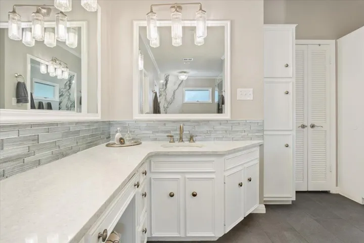 So much storage everywhere in this home....On the right in this photo, you see extra cabinets & there are extra cabinets on the wall across from them as you enter the primary bathroom...