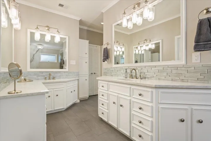 Here you can see both vanities PLUS a make-up vanity on the left.  Quartz countertops. Two framed mirrors on the vanity side as well...