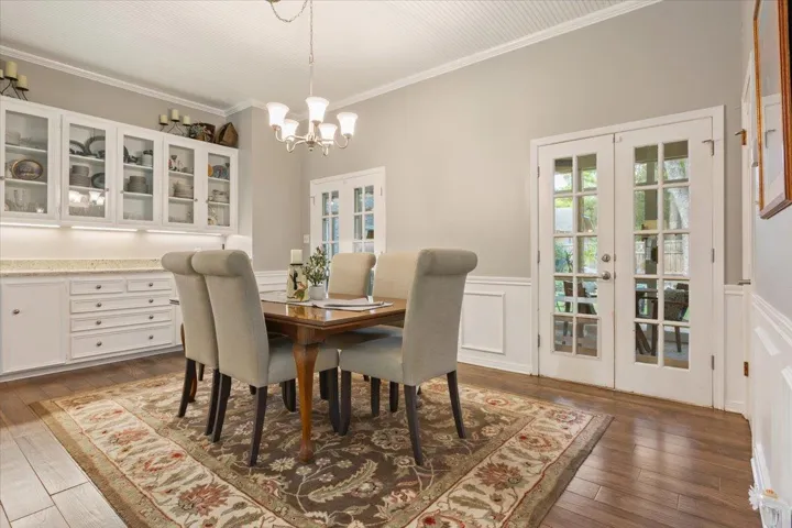 Just around the corner from the kitchen is a truly flexible & incredible dining room.  This room has built-in upper cabinets with glass panes & lower cabinets as well...plus a granite counter top serving area.  Two sets of glass paned French doors lead to the heated, cooled, & enclosed patio....