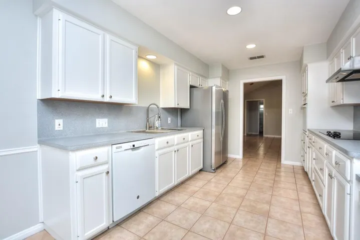 Kitchen with white cabinetry, light countertops, dishwasher, and recessed lighting
