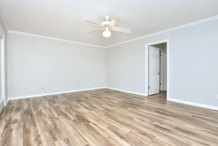 Spare room featuring ornamental molding, light wood-style floors, and a ceiling fan