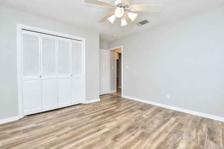 Bedroom with a closet, a ceiling fan, and light wood-type flooring
