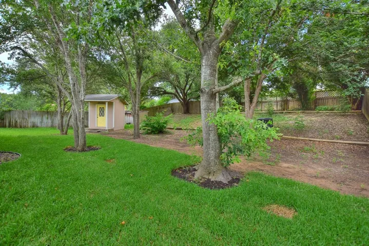 Fenced backyard with a storage shed