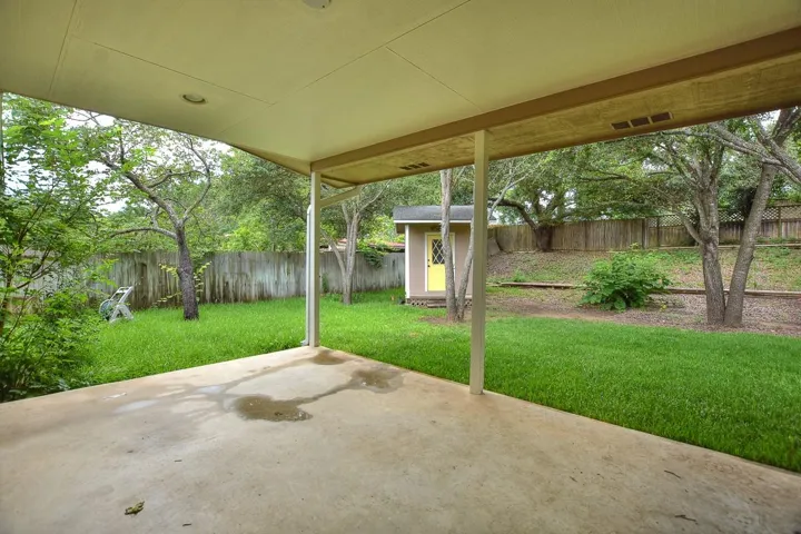 Fenced backyard with a patio and an outdoor structure