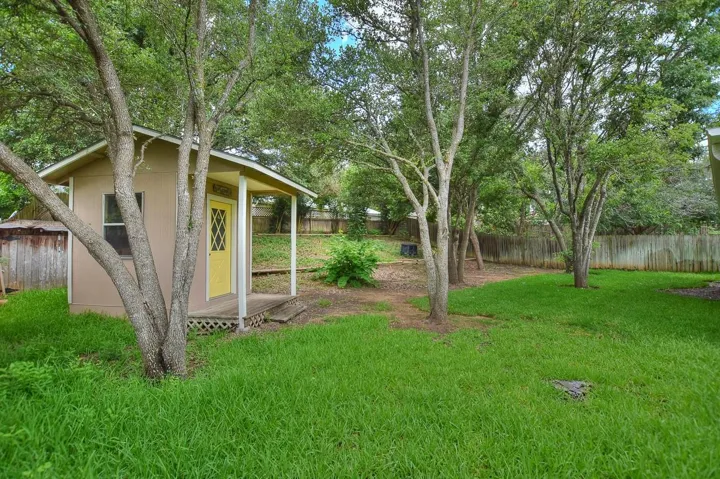 Fenced backyard featuring an outdoor structure