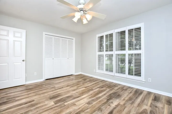 Bedroom with a closet, a ceiling fan, and wood finished floors