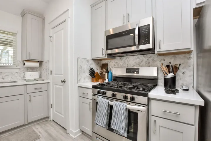 Kitchen with tasteful backsplash, a sink, light countertops, appliances with stainless steel finishes, and light wood-style floors