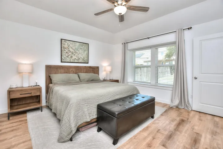 Bedroom featuring light wood finished floors, baseboards, and ceiling fan