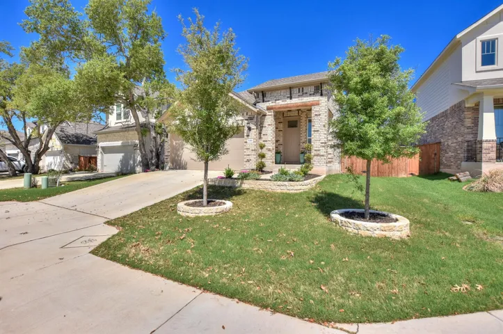 View of front facade featuring concrete driveway, a front yard, and fence