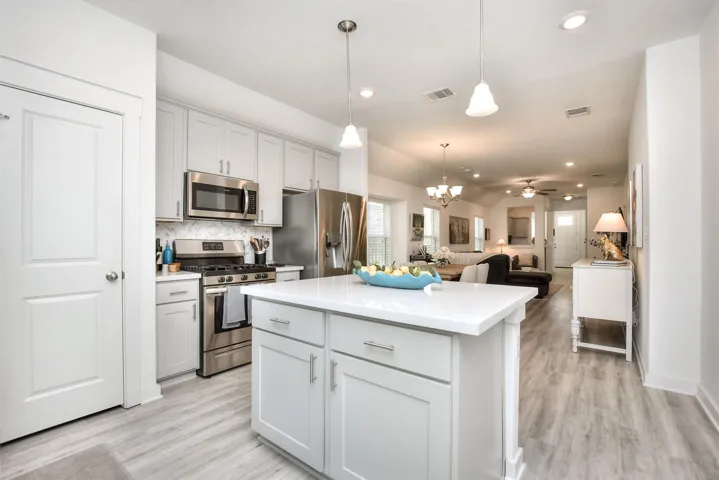 Kitchen featuring visible vents, light countertops, appliances with stainless steel finishes, and a center island