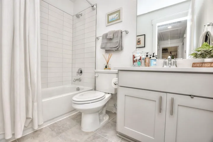 Bathroom featuring tile patterned flooring, shower / tub combo, vanity, and toilet