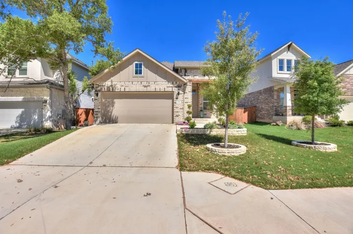 View of front of home with a front yard, an attached garage, board and batten siding, and concrete driveway
