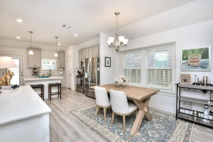Dining room featuring light wood-type flooring, baseboards, a chandelier, recessed lighting, and visible vents