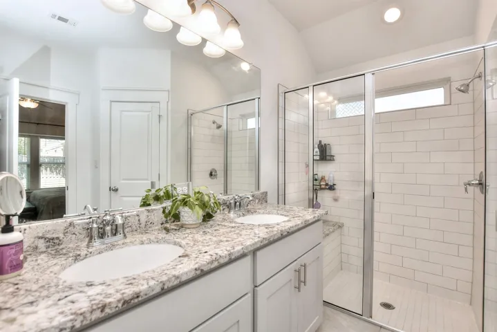 Bathroom featuring a sink, visible vents, and a stall shower